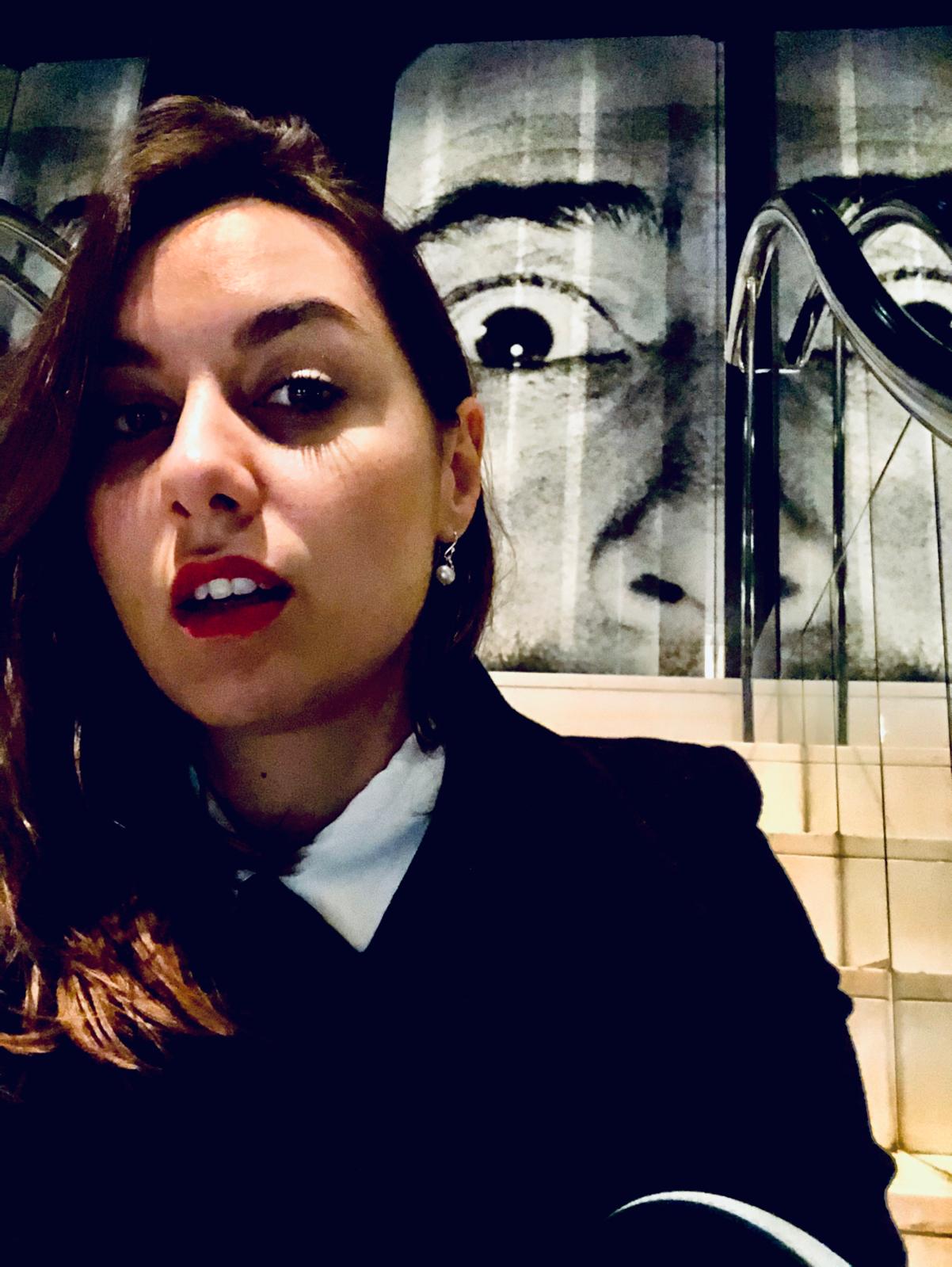 Ivaneta in front of a large black and white portrait projection