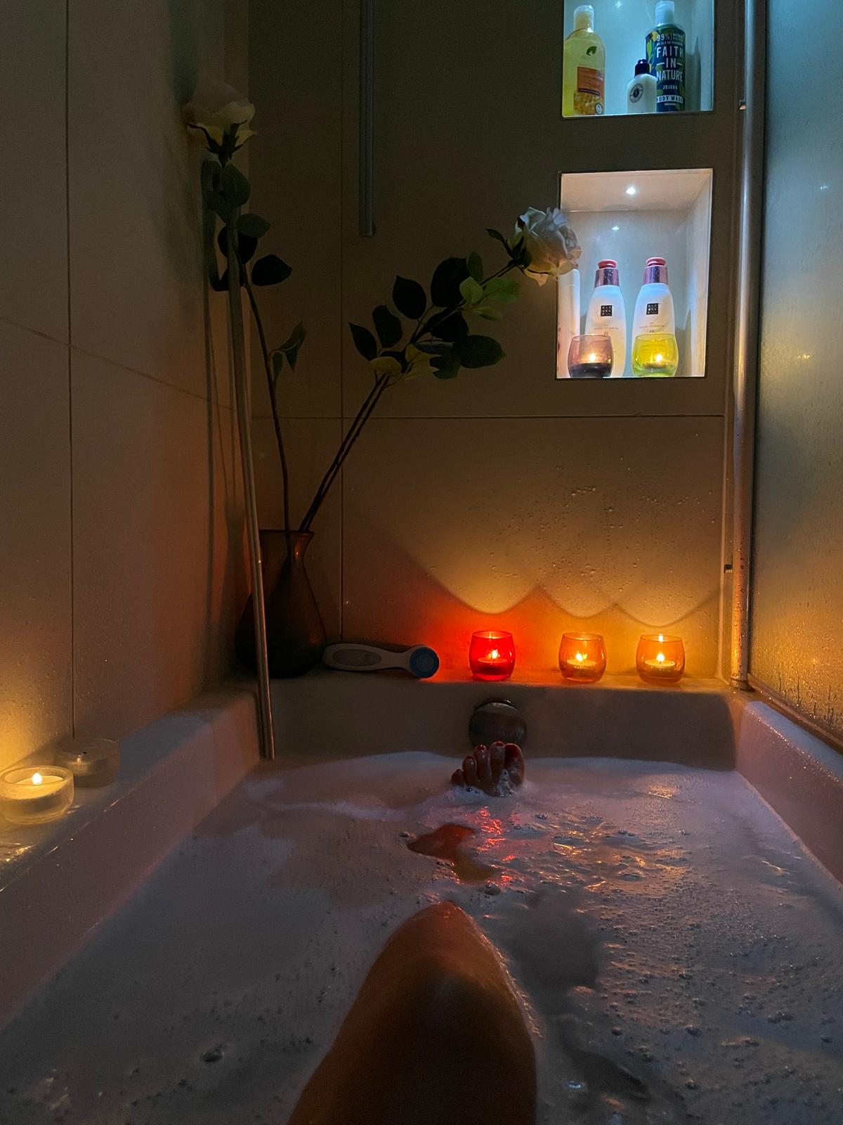 Candlelit bath with white roses and warm light